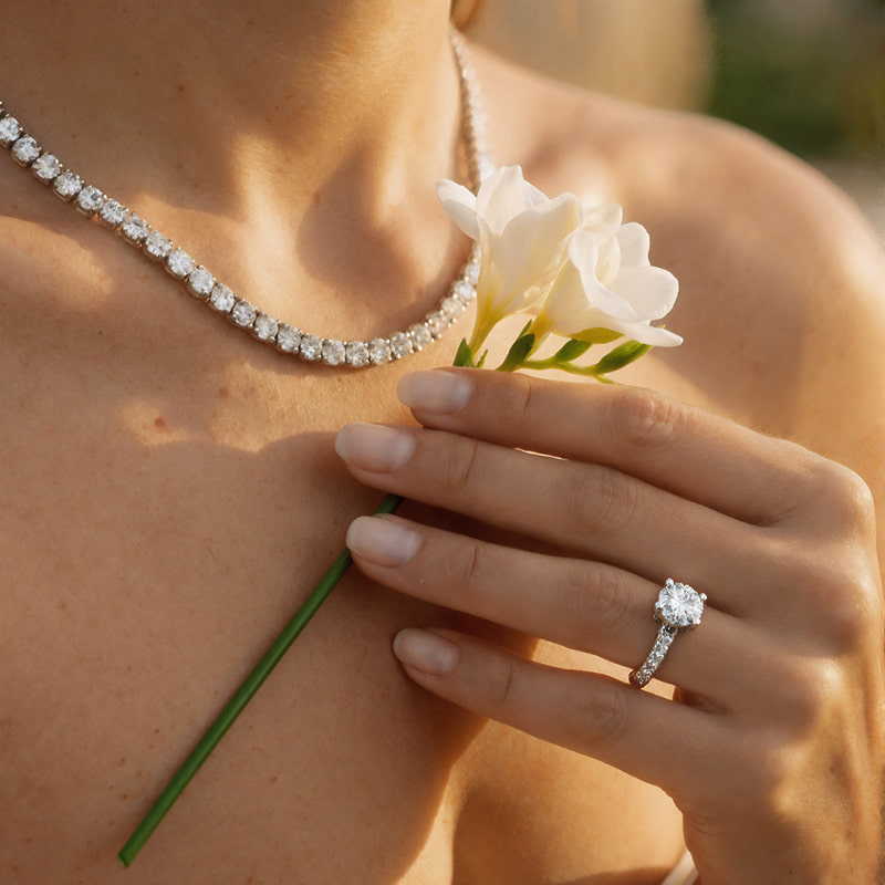 Mano femminile con riviera  di diamanti e anello solitario in oro - gioielleria Karatis di Bellavere Abano Terme